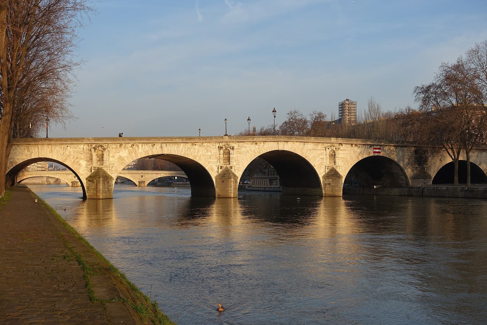 The stone arches of the Pont Marie crossing the Seine to the Île Saint-Louis in soft evening light
