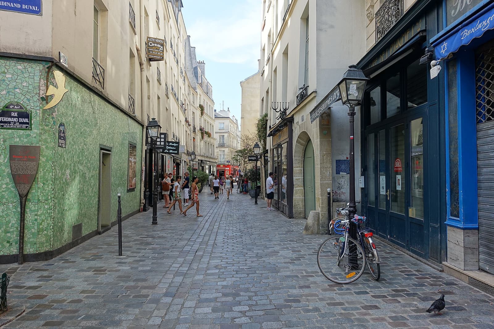 People walking along the narrow, shop-lined Rue des Rosiers in the Marais