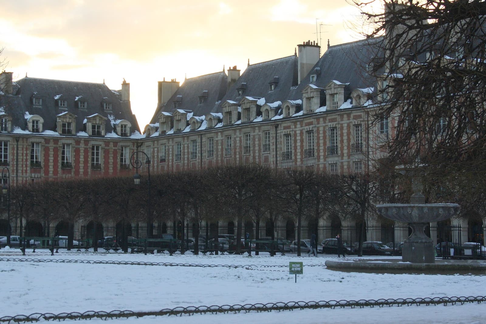 The Place des Vosges with snow on the lawns in winter